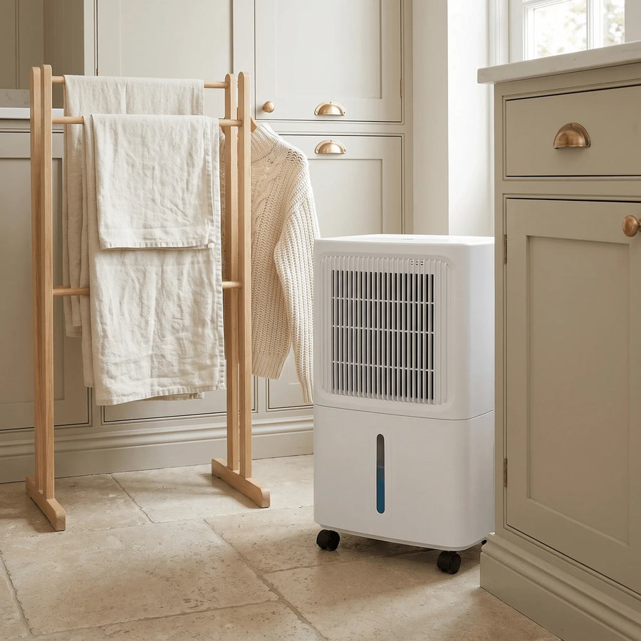 12L compressor dehumidifier next to a drying rack in a utility room