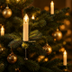 Clip-on LED candles glowing on a Christmas tree